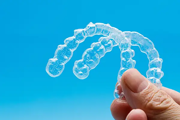 Close up of hand holding invisalign clear aligners at  Radiance Dental in West Chester, PA